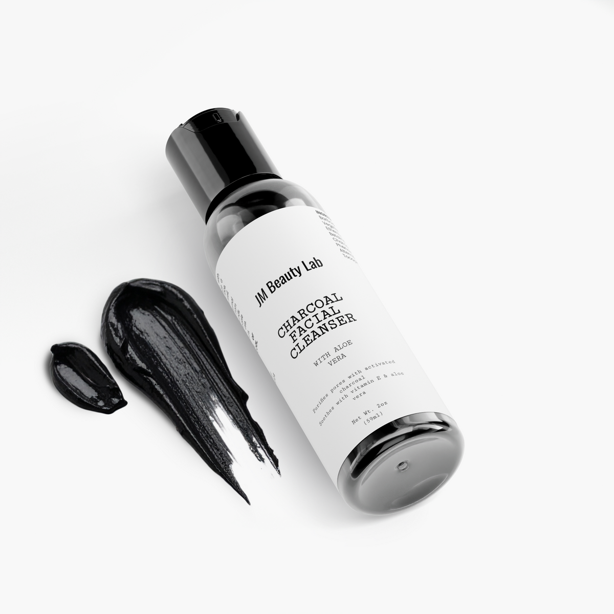 Charcoal facial cleanser bottle with black cap and dark cleanser swatches