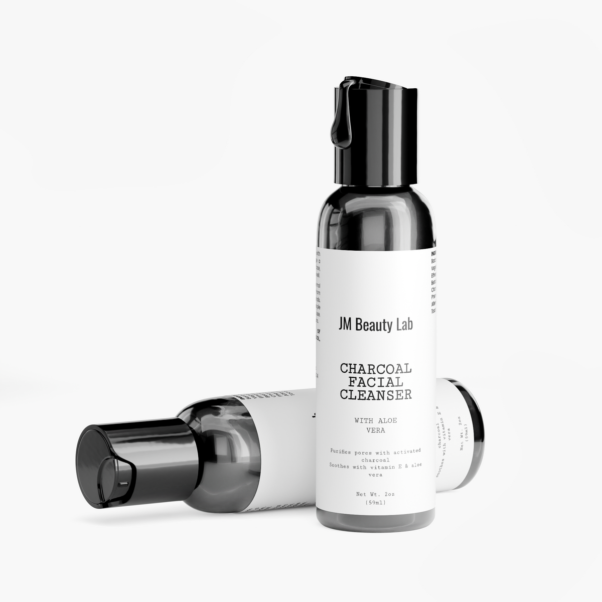 Charcoal facial cleanser bottles, one with black pump cap open, JM Beauty Lab