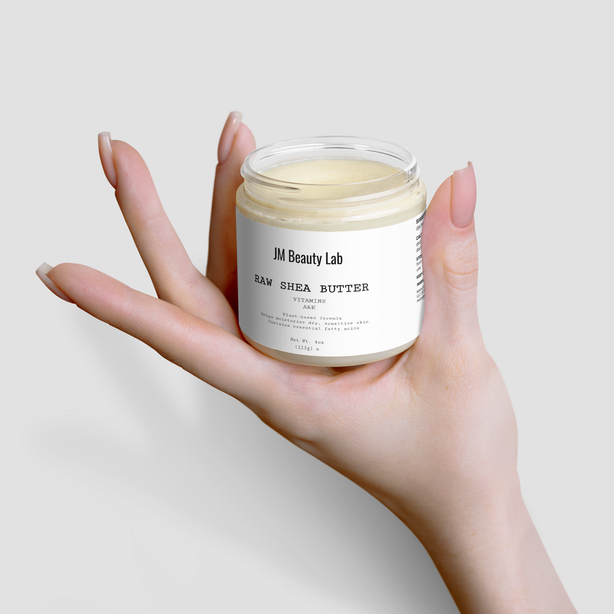 Raw shea butter jar in open hands, creamy jar visible with black lid