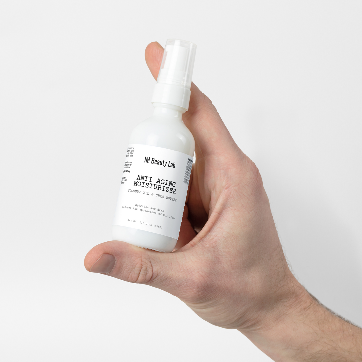 Moisturizer bottle held in hand, front label facing camera